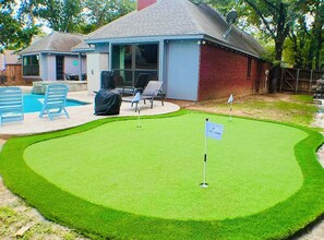 Ein Minigolfplatz mit Putting Green, einer Fahne und einem Flaggenstock.
