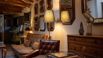 Een gezellige woonkamer met een leren bank, een glazen salontafel en een houten kast.
