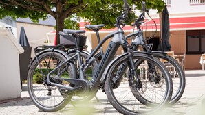 A bicycle parked on a paved surface with a building in the background.
