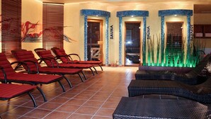 A spa area with red chairs, a massage table, and a decorative water feature.