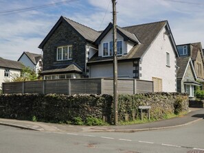 A two-story house with a stone facade and a grey roof. - Rose House (Windermere)
