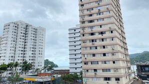A tall, multi-story building with numerous windows and air conditioning units.