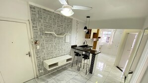 A modern kitchen with a marble floor, a built-in bar area, and a ceiling fan.