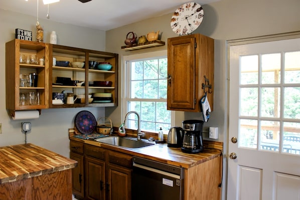 A kitchen with wooden cabinets, a built-in sink, and a clock on the wall. - Romantic Couples Escape | Dogs Stay Free | Hot Springs, NC | The Bailey (Hot Springs)