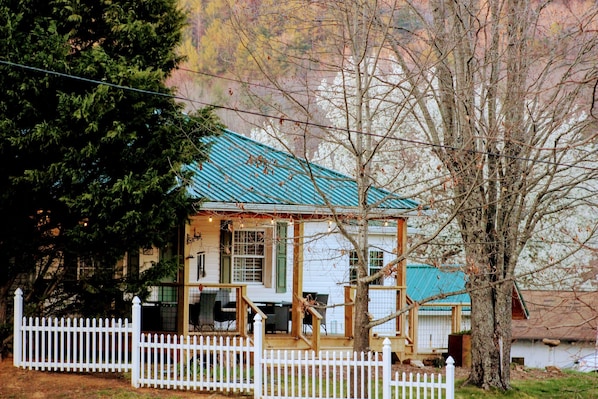 A house with a porch, a fenced yard, and a large tree. - Romantic Couples Escape | Dogs Stay Free | Hot Springs, NC | The Bailey (Hot Springs)