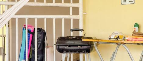 A room with a suitcase, a grill, and a toy car on a table.