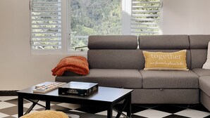 A living room with a grey sofa, a black coffee table, and a chess board. - El Yunque Rainforest Villa, Pool, Toro Trail, 5-Acre Hacienda, Fruit Trees (Canóvanas)