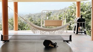 A hammock chair in a covered outdoor area with a view of a lush landscape. - El Yunque Rainforest Villa, Pool, Toro Trail, 5-Acre Hacienda, Fruit Trees (Canóvanas)
