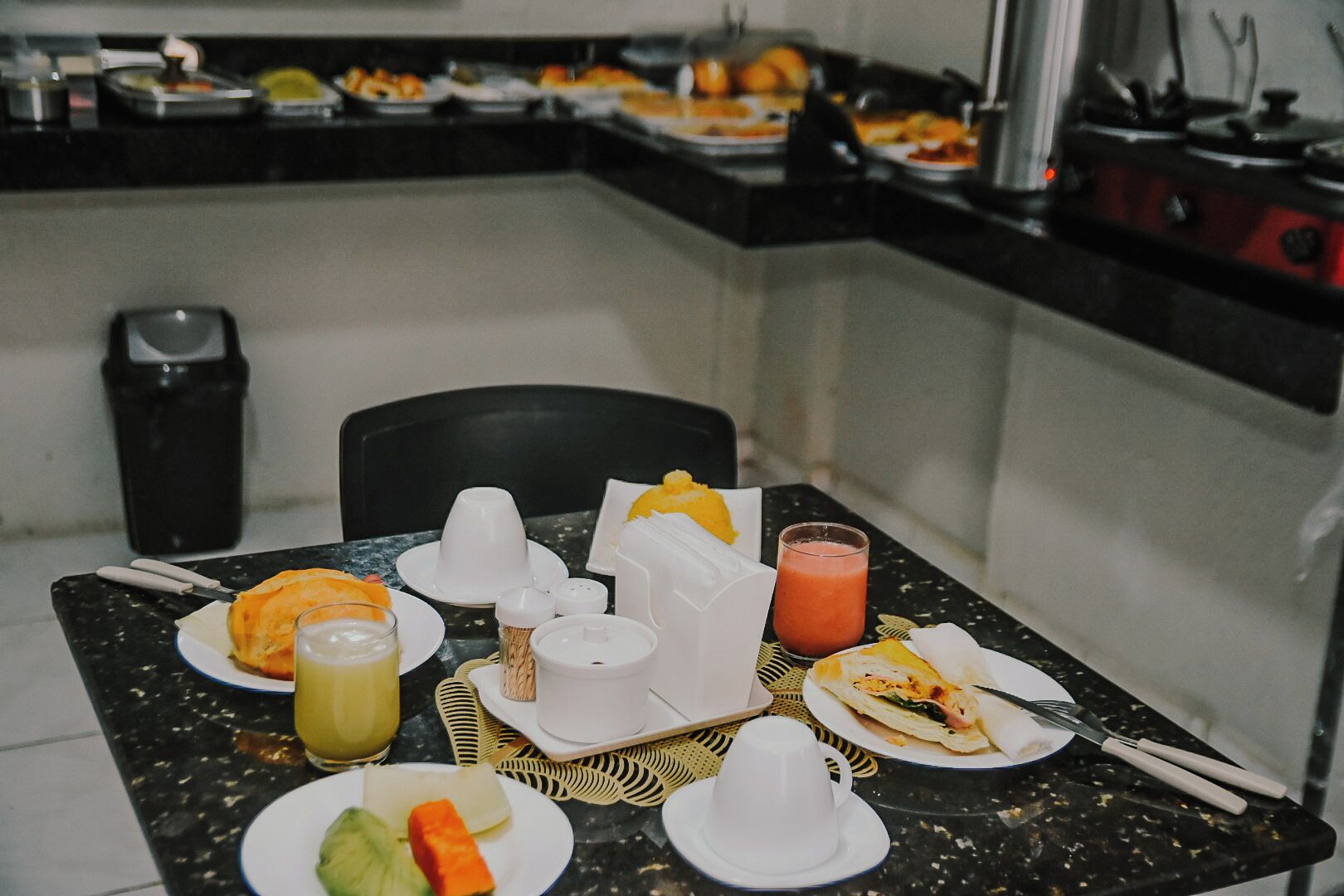 Um buffet de café da manhã com diversas opções de comida e bebidas.