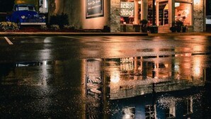 A building with a sign for 'Laurel Mercantile' and 'Satinman' at night. - Experience Mississippi Art at 'The Artistry' (Laurel)