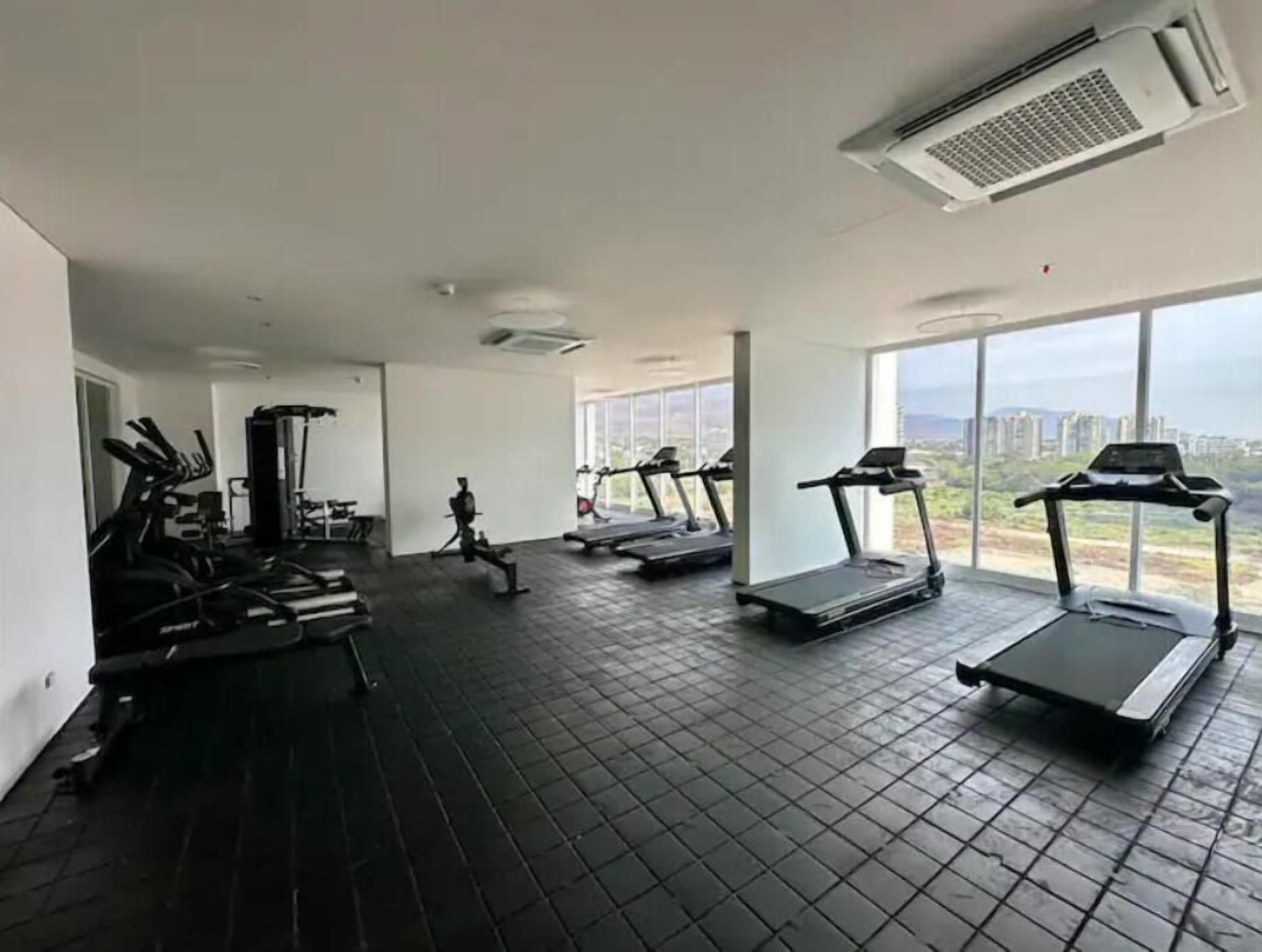 Academia com esteiras, bicicletas ergométricas e máquinas de musculação.