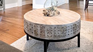 A round dining table with a wooden top and metal base, set on a rug in a room with hardwood floors, white walls, and a kitchen in the background. - Centrally Located Downtown, Full Kitchen, Patio (Laurel)