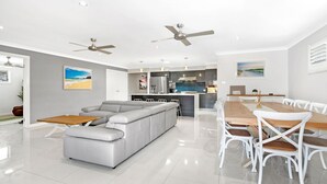 A modern kitchen with dark cabinets, a stainless steel refrigerator, and a central island.