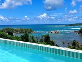 Una piscina con vistas al océano y follaje.
