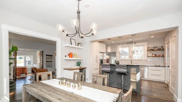 A spacious kitchen with a central island, wooden dining table, and pendant lighting. - StayDelta | Hyde Park (Cincinnati)