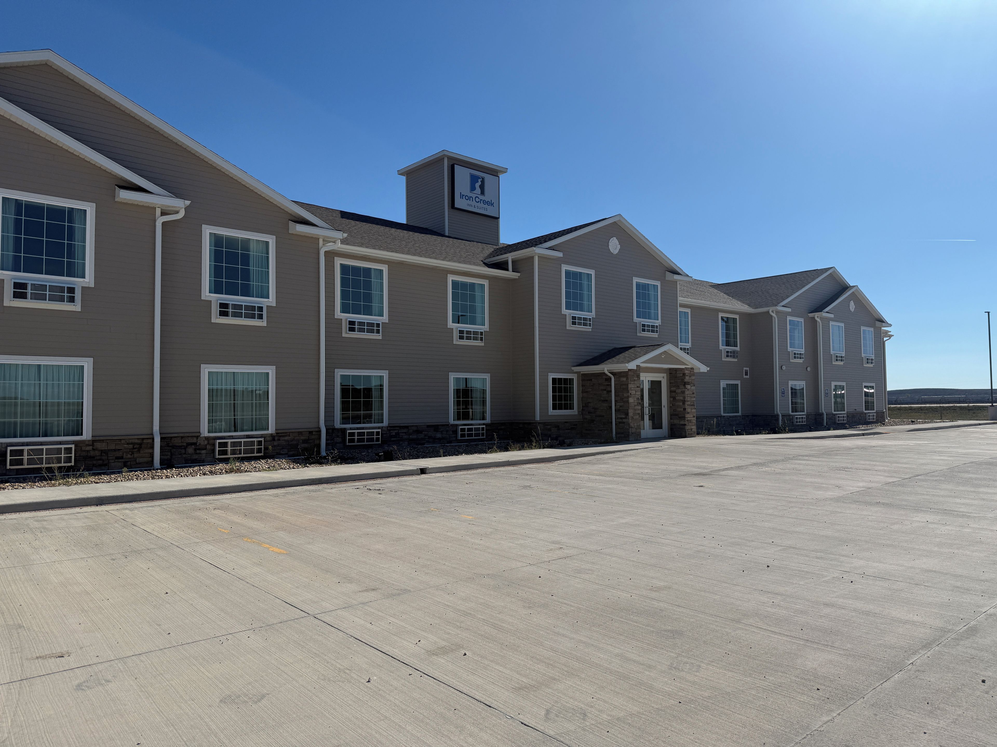 A multi-story building with a flat roof, large windows, and a central entrance.