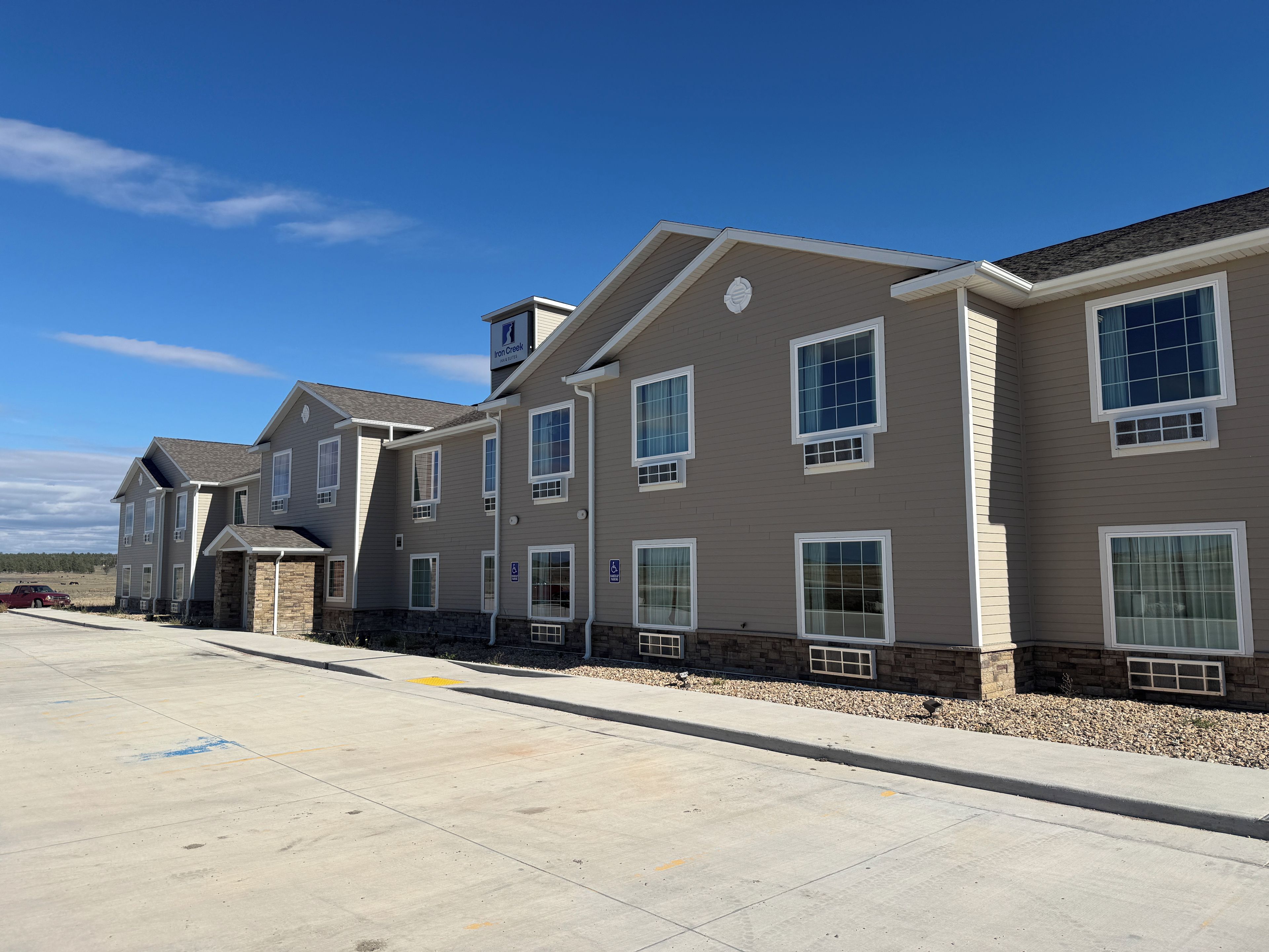 A row of townhouses with a stone foundation, multiple windows, and a clear sky.