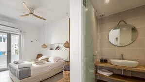 A modern bedroom with a bed, bedside table, and a large mirror. - Elyos Apartment Ermes (milos)