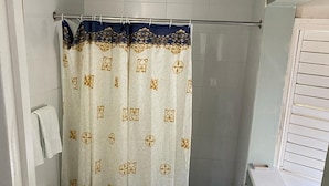 Baño pequeño con inodoro, cortina de ducha y ventana.