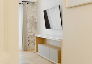 Ein Flur mit Heizkörper, weißer Wand und einem gerahmten Bild.