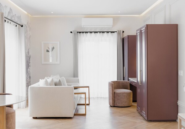 A modern living room with a sofa, a chair, a small table, and a cabinet. - Maria Camille Hotel Boutique (San Miguel de Allende)