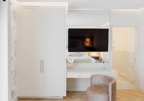 Un baño moderno con tocador, espejo y un mueble de almacenamiento grande.