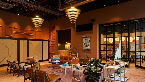 A spacious lobby with a traditional Asian-inspired decor, featuring a large seating area, a coffee table, and a potted plant. - 25hours Hotel Paper Island (Copenhagen)