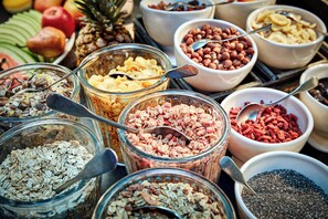 A variety of food items in bowls and jars, including oats, nuts, and dried fruits. - 25hours Hotel Paper Island (Copenhagen)