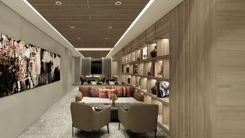 A modern interior with a long hallway, a seating area with a sofa and chairs, and a bookshelf with decorative items.