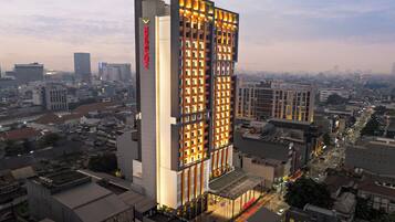 A high-rise hotel with a modern design, featuring a prominent vertical sign and illuminated facade.