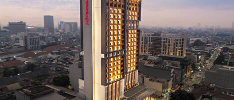 A high-rise hotel with a modern design, featuring a prominent vertical sign and illuminated facade.