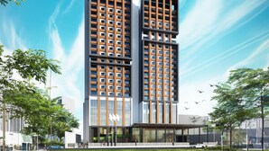 A modern high-rise building with a unique architectural design, featuring two vertical sections with large windows and a flat roof. - Mövenpick Hotel Jakarta City Centre (Jakarta)