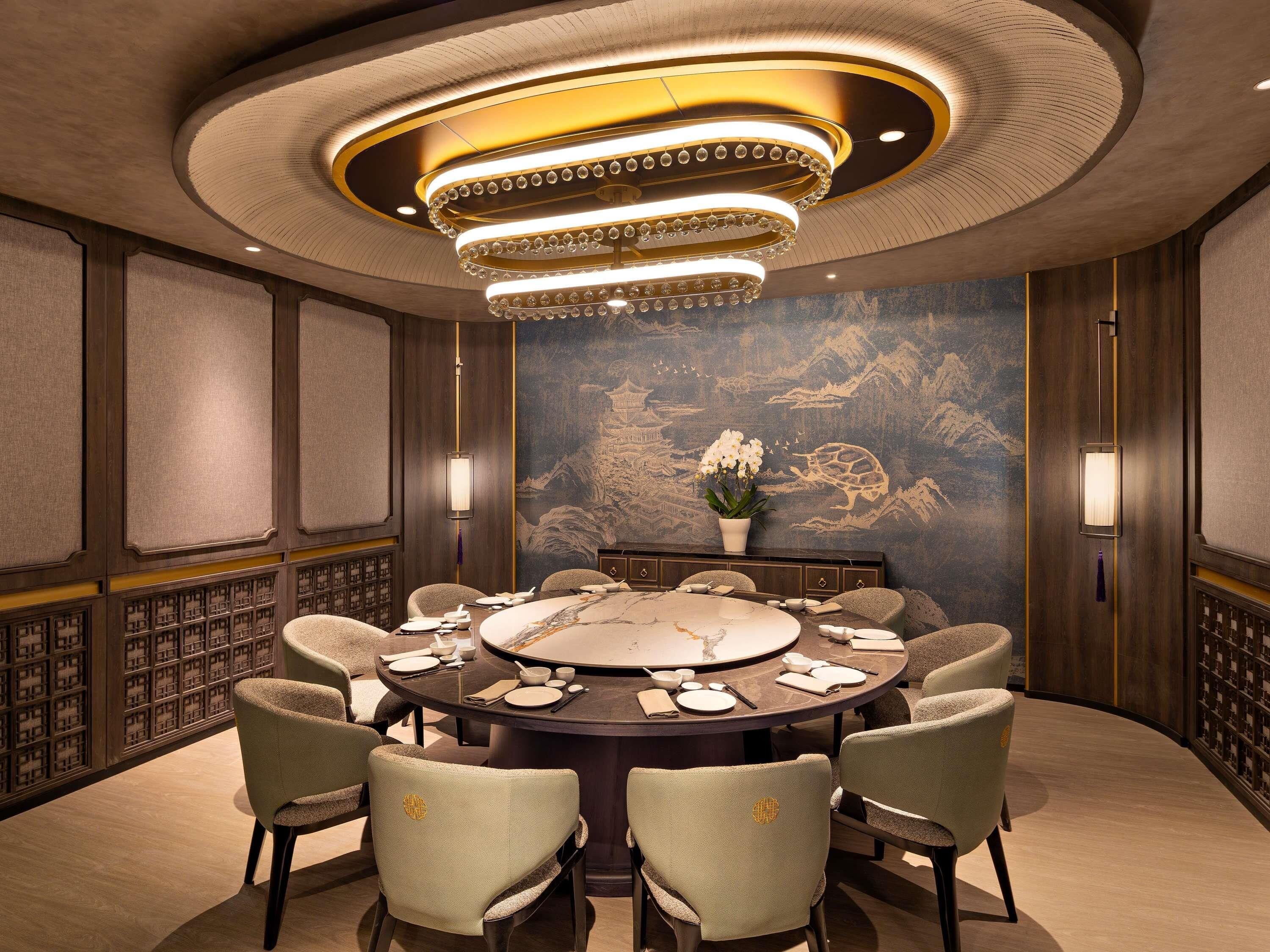 A conference room with a round table, chairs, and a chandelier.