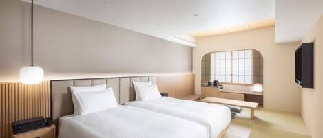 A modern hotel room with a large bed, bedside tables, a mirror, and a flat-screen TV.