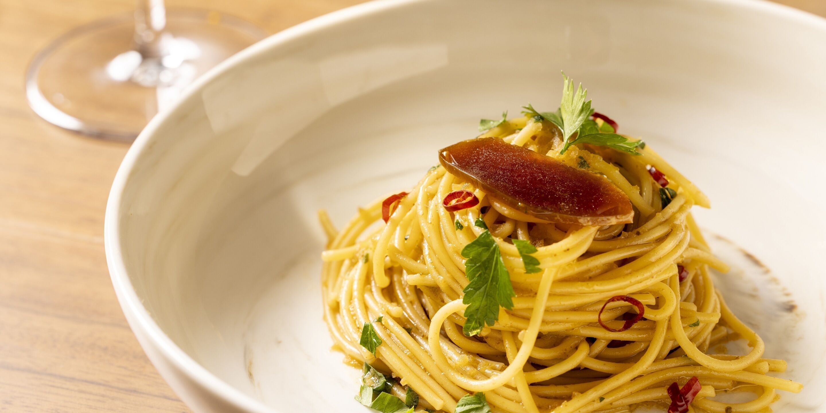 A bowl of spaghetti with garnishes.