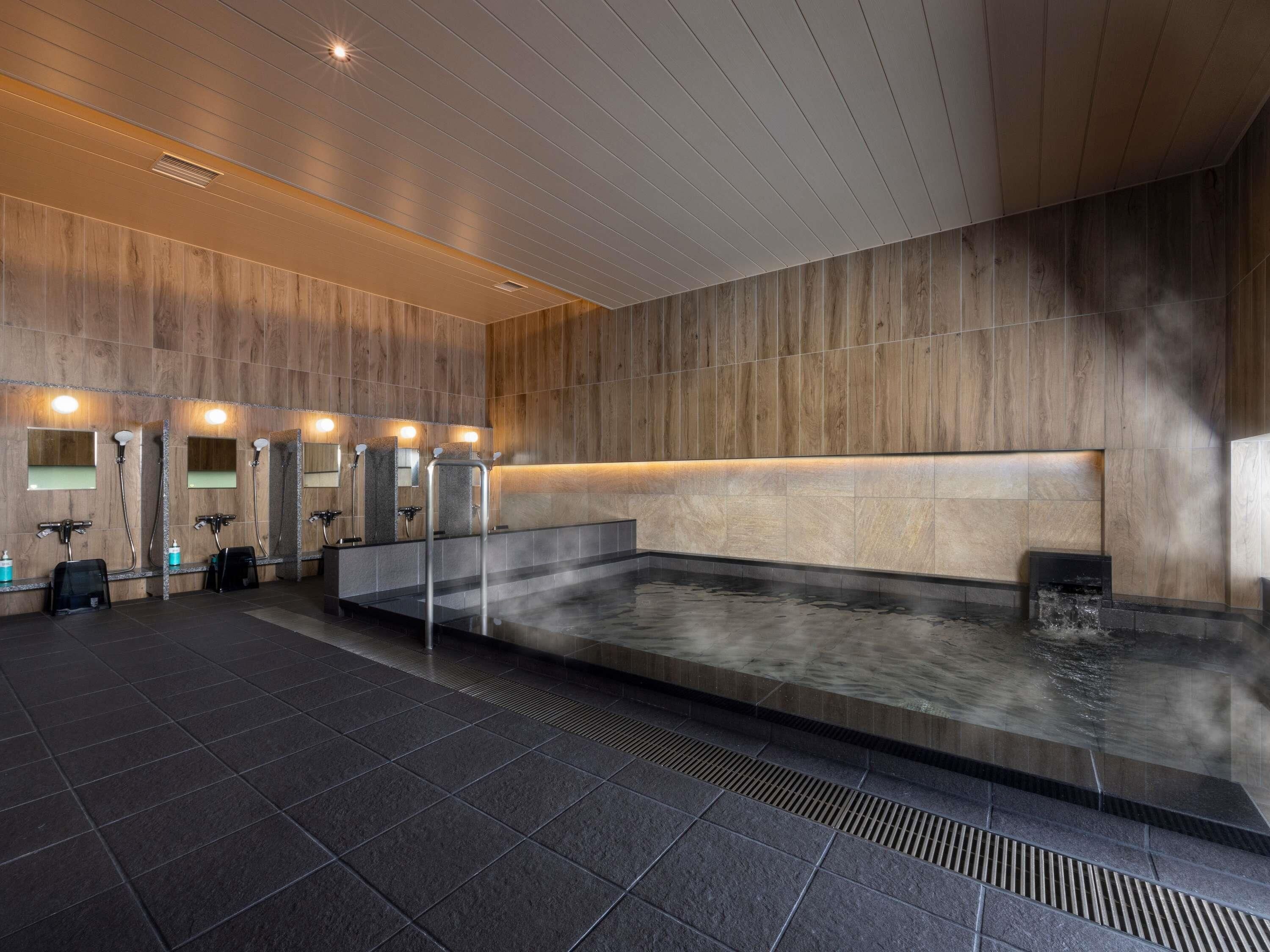 A modern bathroom with multiple sinks, a heated floor, and a large mirror.
