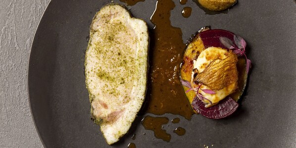 A plate with a piece of fish, a slice of beet, and a dollop of sauce. - Novotel Nara (Nara)