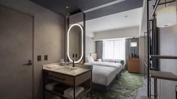 Habitación de hotel con un espejo grande, un lavabo, dos camas, una mesita y un armario.