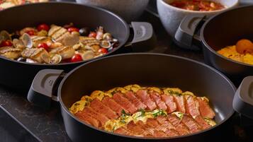 A variety of dishes in black pots on a countertop.