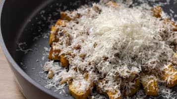 Tofu cubes in a pan with shredded coconut on top.