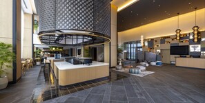 A spacious lobby with a central reception desk, seating areas, and a high ceiling with a geometric pattern. - Novotel Nara (Nara)