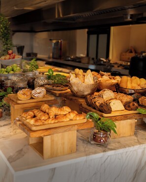 A buffet spread with various breads, pastries, and fruits. - Novotel Riyadh Sahafa (Riyadh)