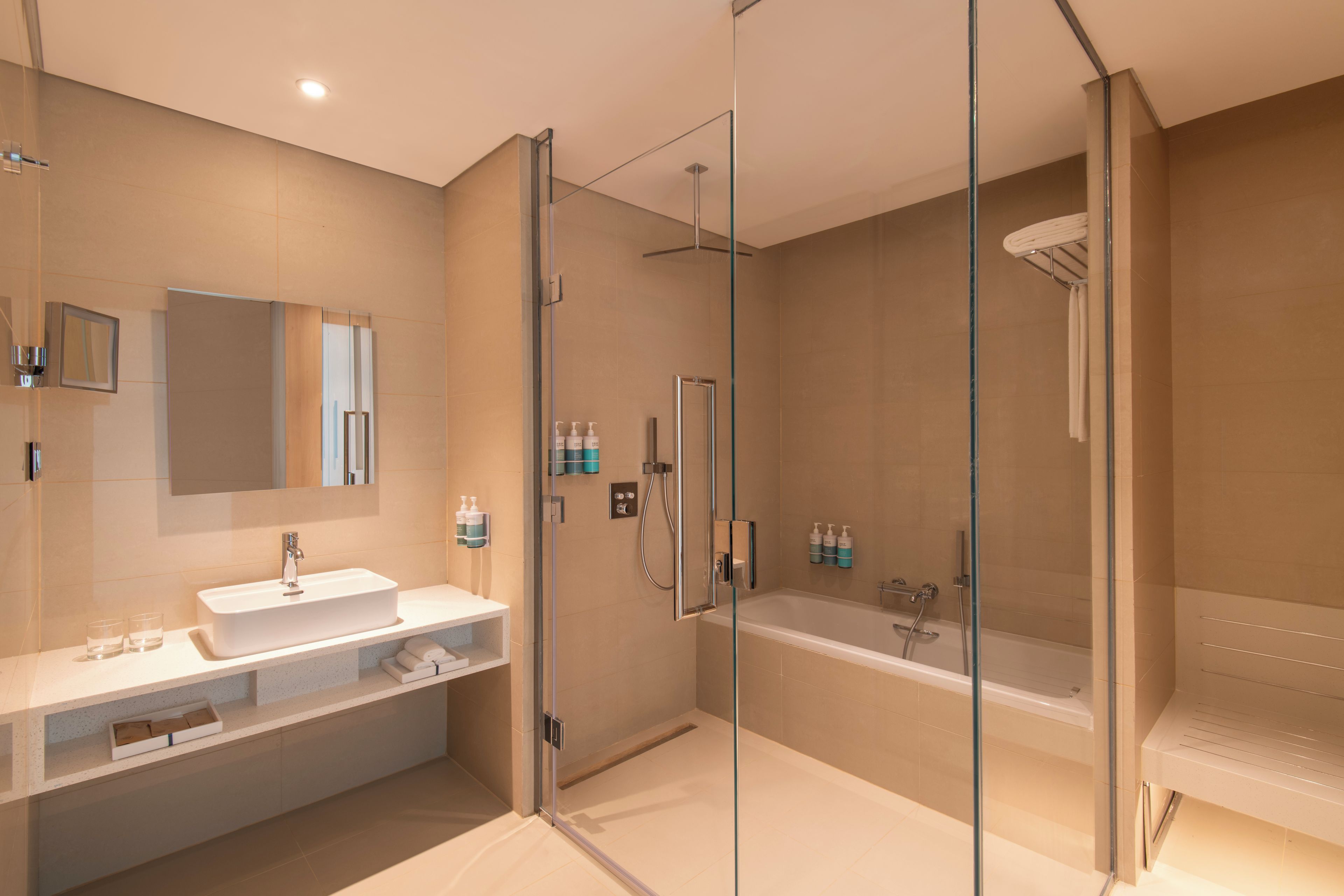 A modern bathroom with a glass-enclosed shower, a standalone bathtub, and a vanity with a sink.