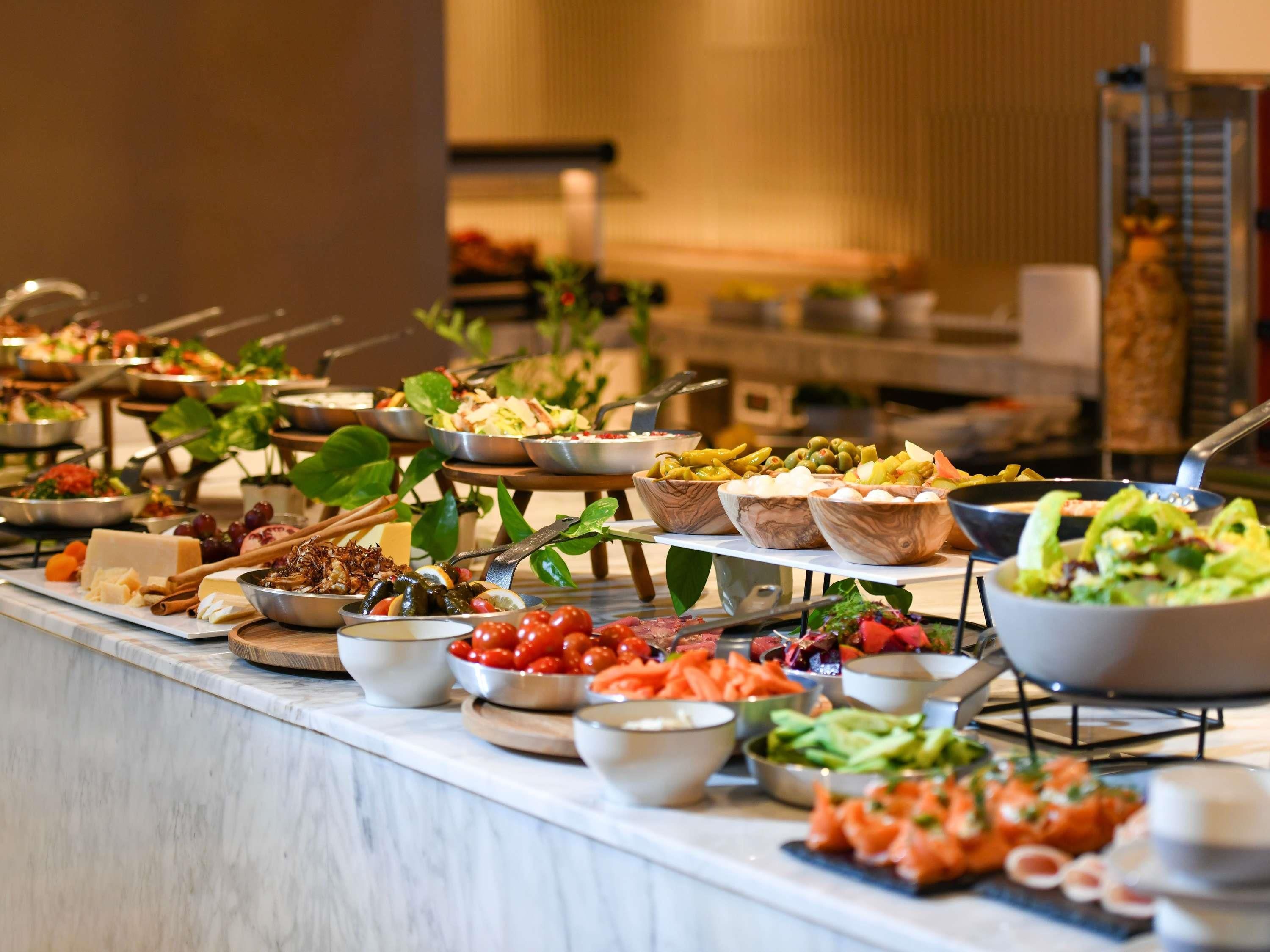 A buffet with various food items including salads, cheeses, and seafood.