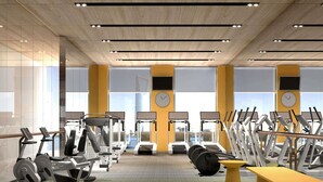Un gimnasio moderno con máquinas de cardio, pesas y una banca.