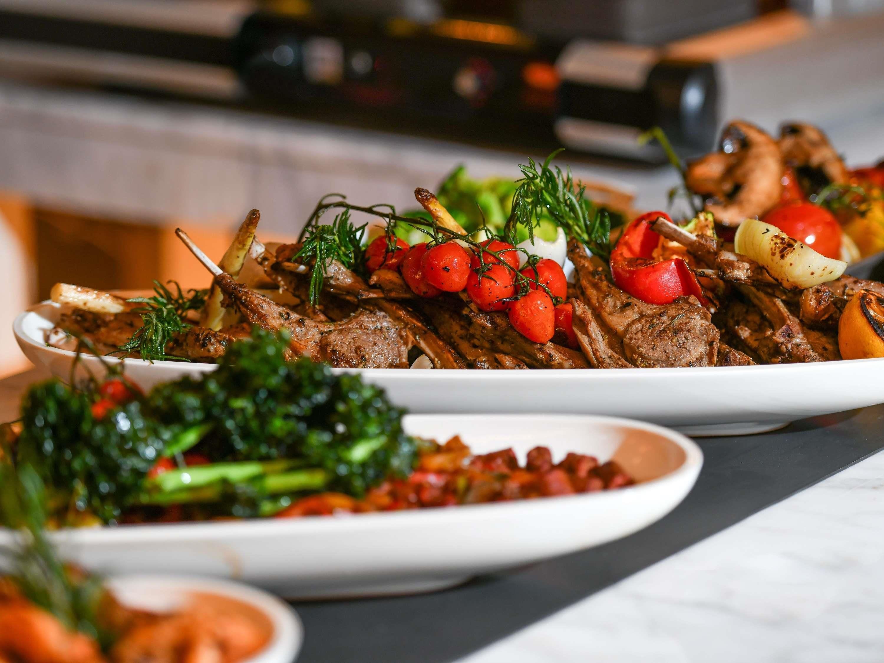 A dining table with various dishes, including grilled meat and vegetables.