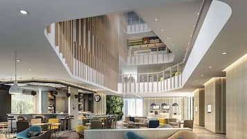 A multi-level interior with a central staircase, a bar area, and seating arrangements.