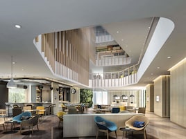 Un interior con varios niveles, una escalera central, una zona de bar y diferentes disposiciones de asientos.