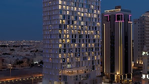 Un hotel modern amb una façana de disseny, finestres il·luminades i un rètol destacat a la part superior.