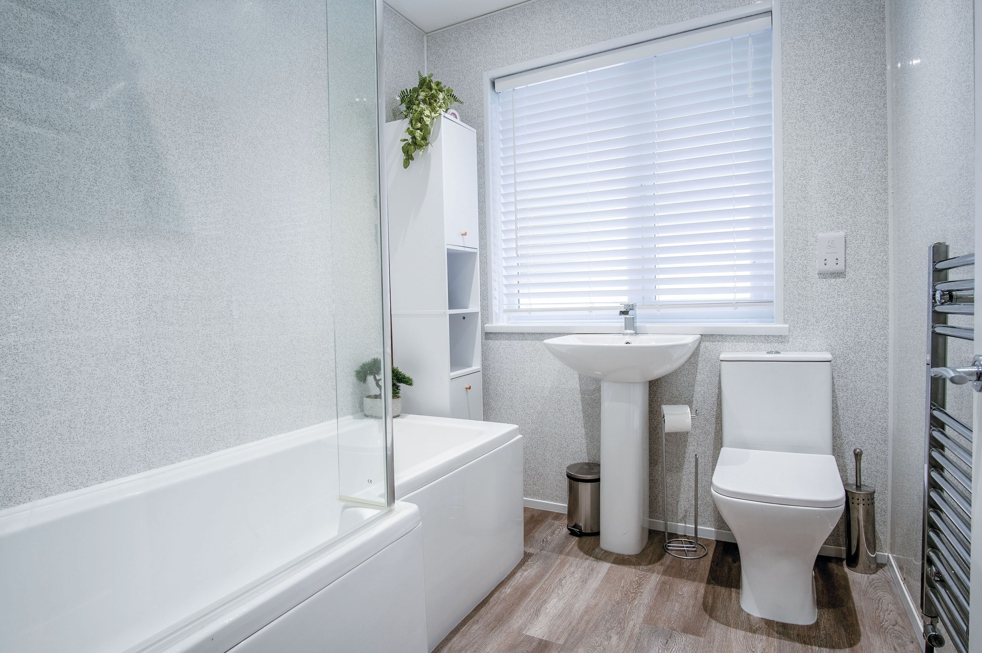 A modern bathroom with a bathtub, sink, and toilet.